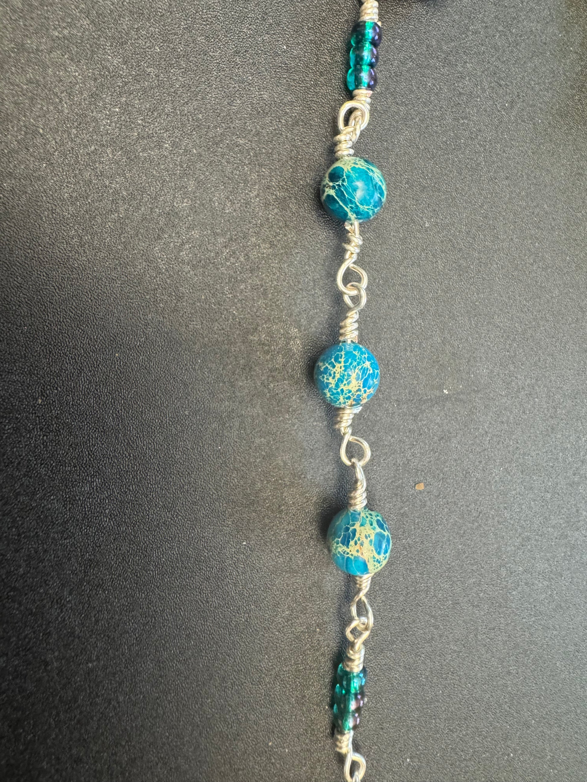 closeup of Ocean jasper single decade rosary with blue crucifix and blue guardian angel centerpiece