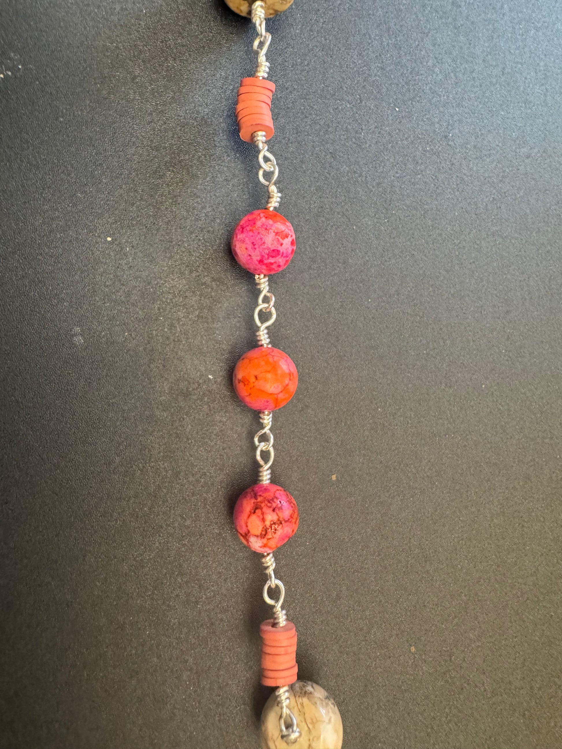 Closeup of Sacred heart of Jesus single decade rosary with pinkish orange beads and red accented crucifix