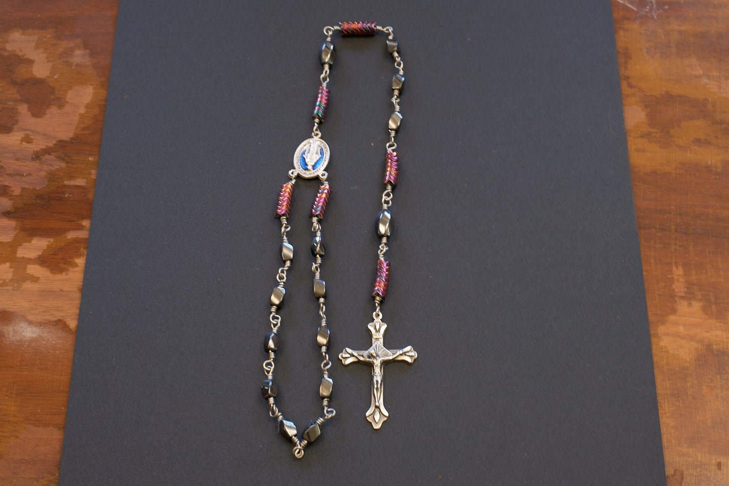 single decade rosary with oval faceted hematite beads and blue miraculous medal centerpiece