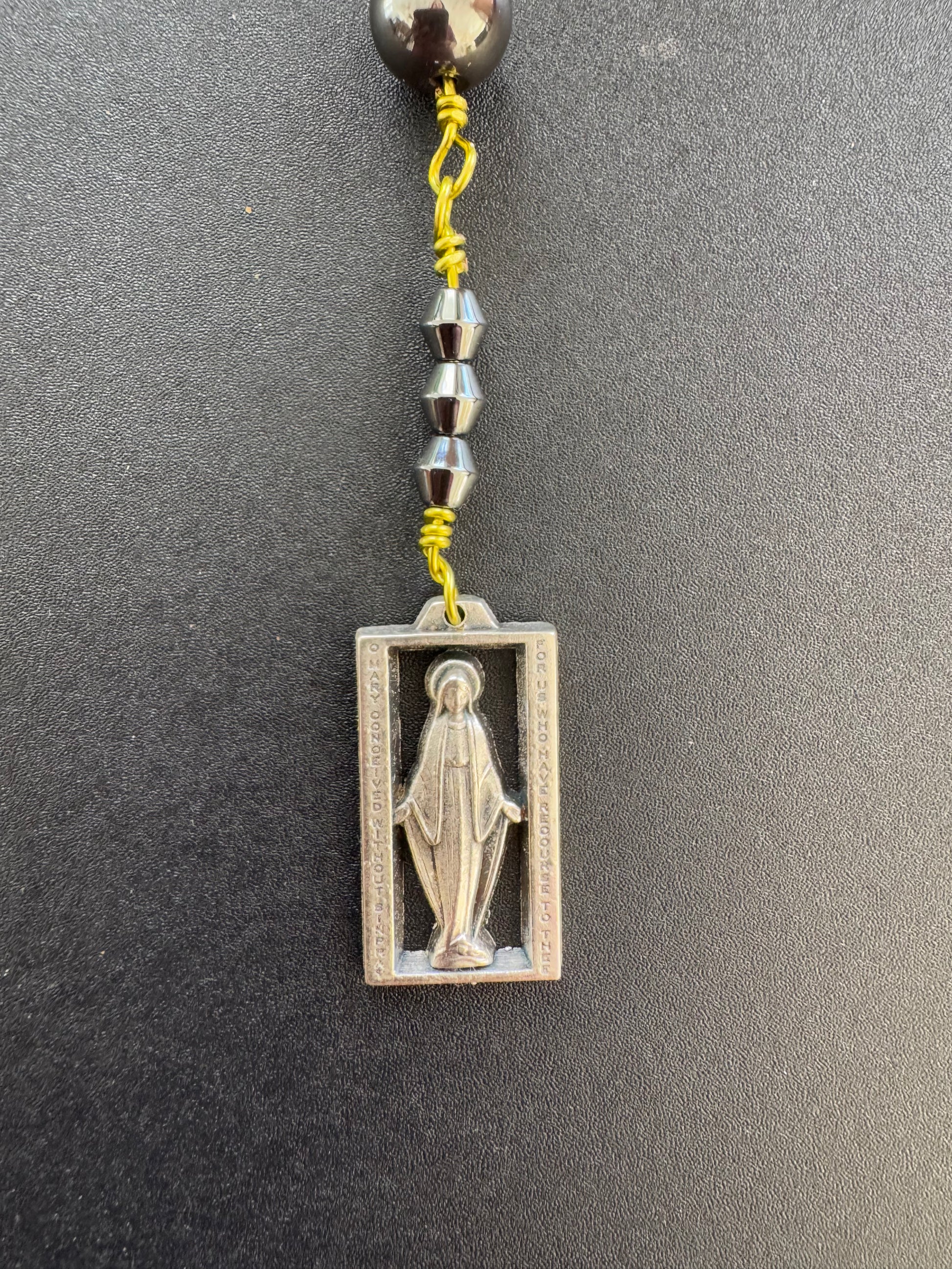 closeup of square Mary medal on chaplet of the immaculate conception