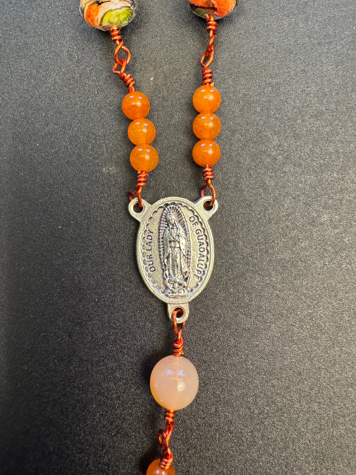Our lady of Guadalupe centerpiece on single decade our lady of Guadalupe rosary with green and orange swirl glass beads and orange colored wire