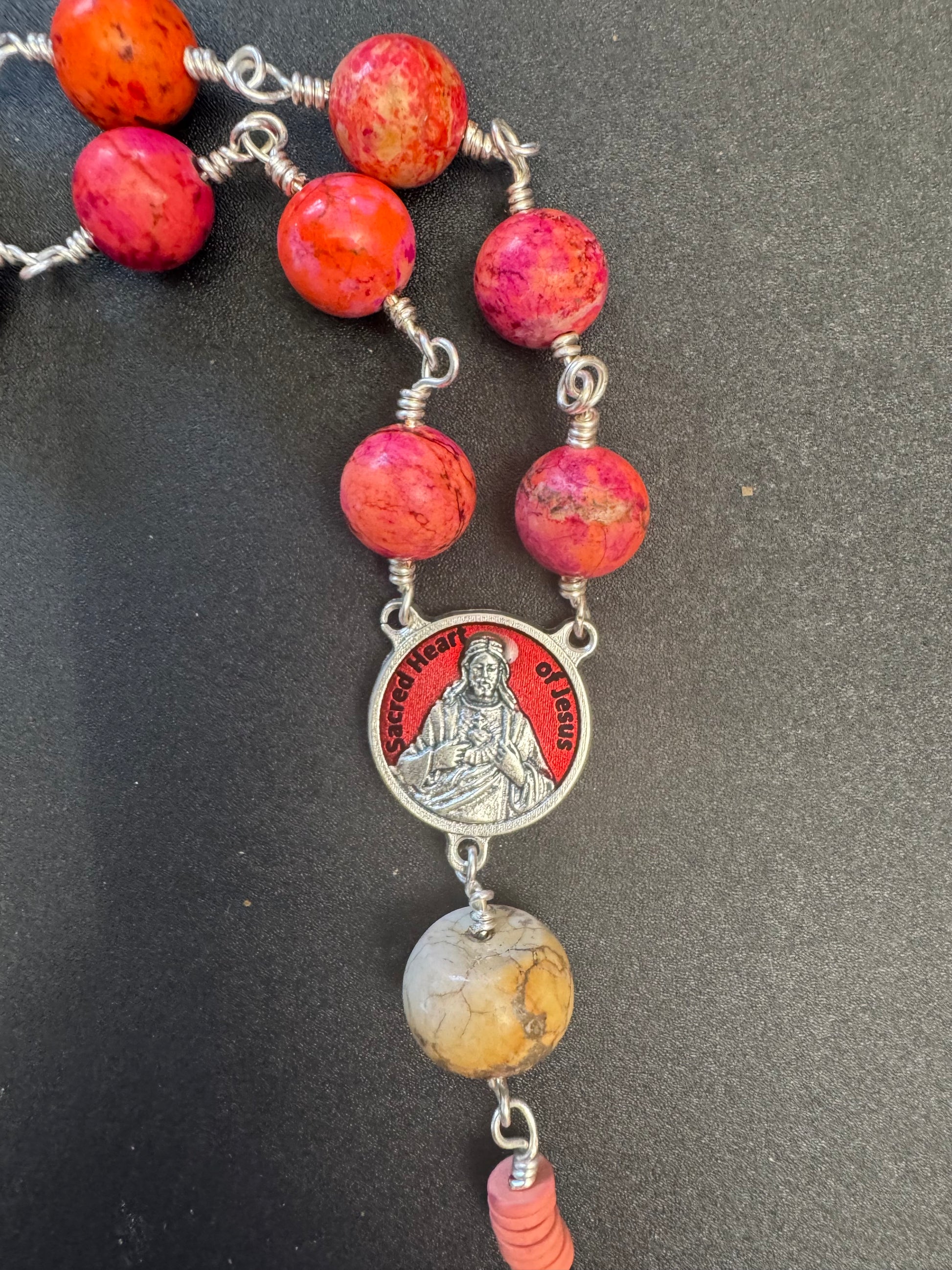 Sacred heart of Jesus red accented centerpiece on single decade rosary with pinkish orange beads and red accented crucifix