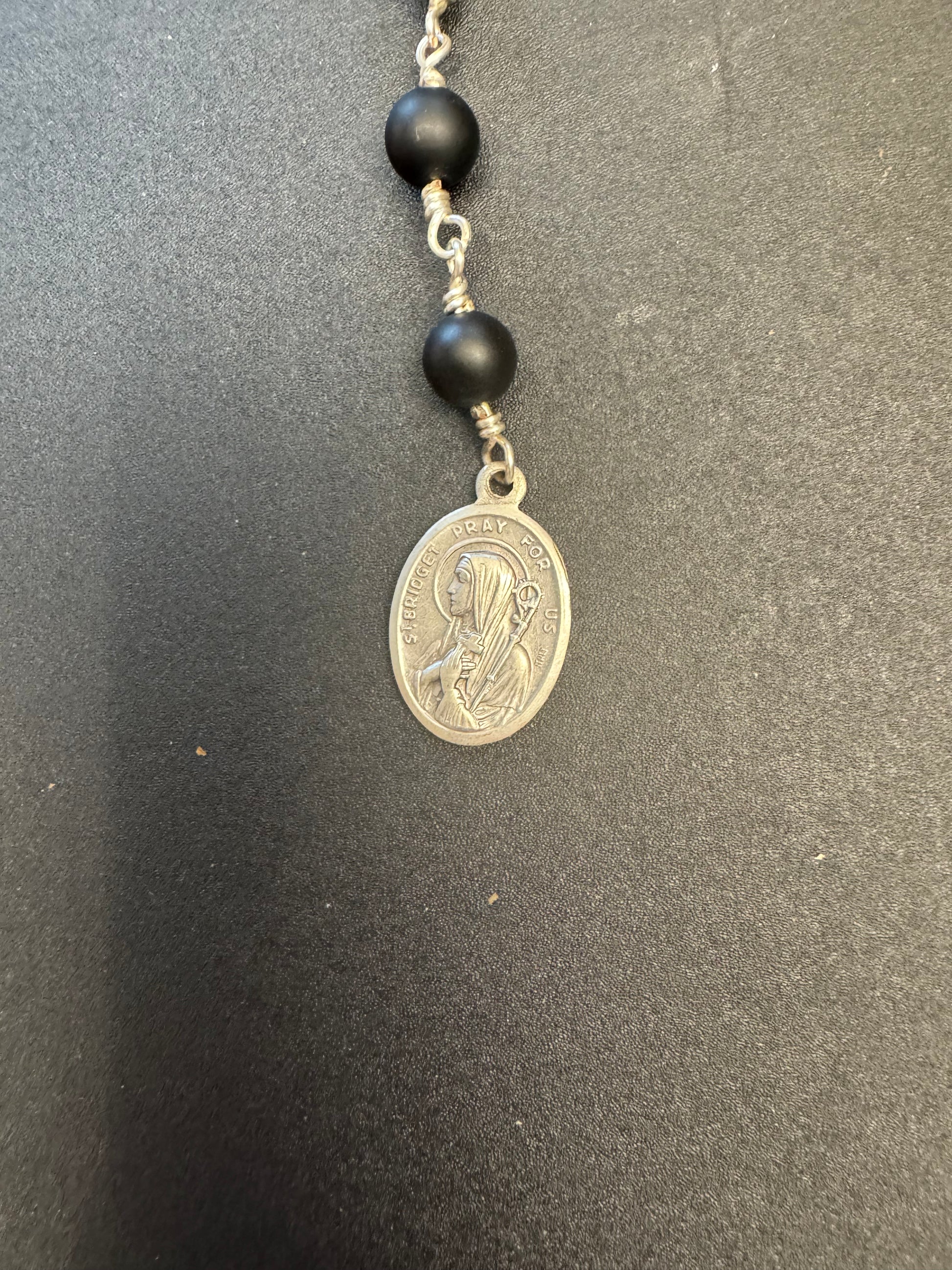 St. Bridget medal on pocket rosary With black matte beads