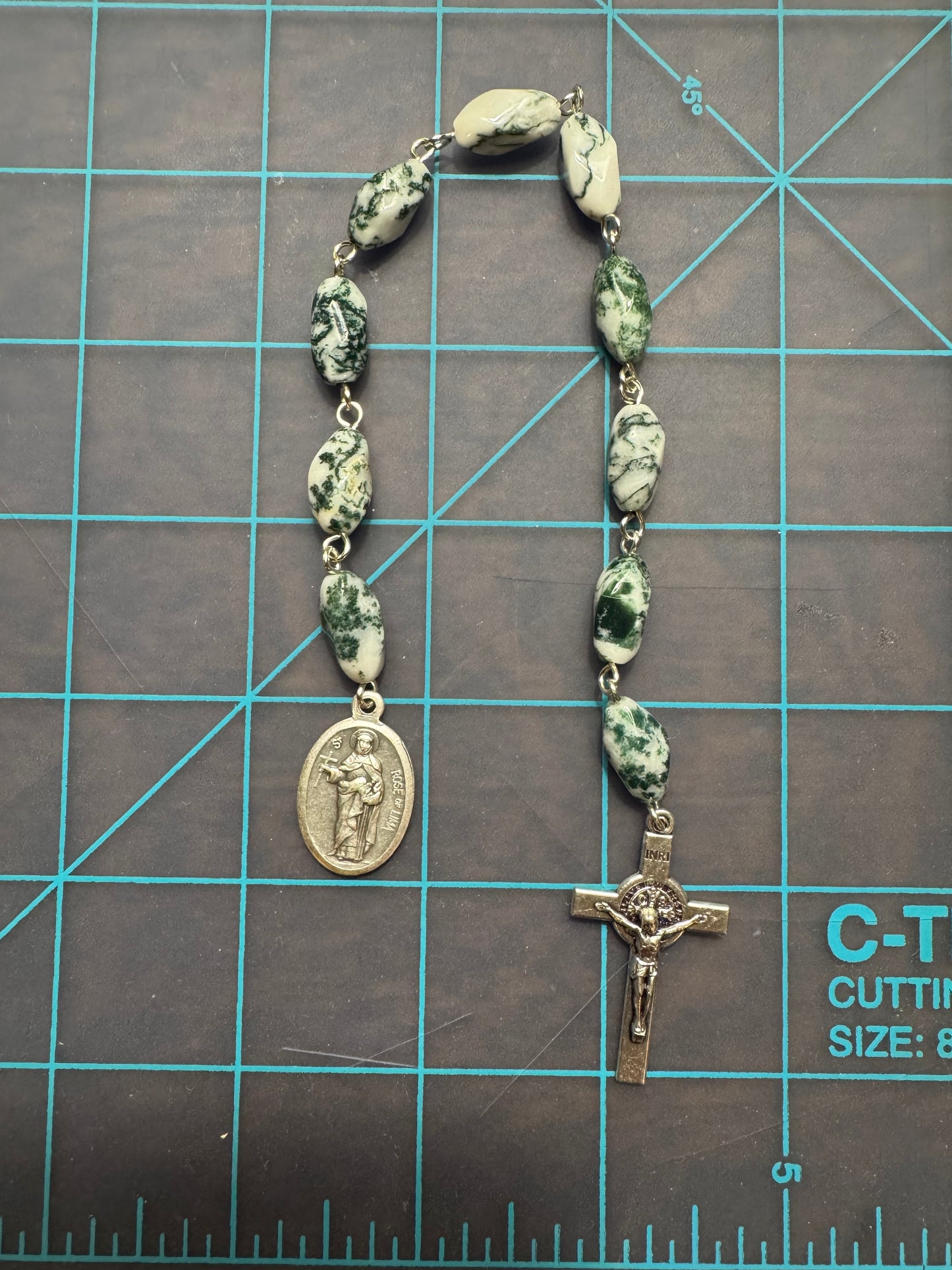 Top down view of St. Rose of Lima Pocket Rosary with green and white swirl stone beads