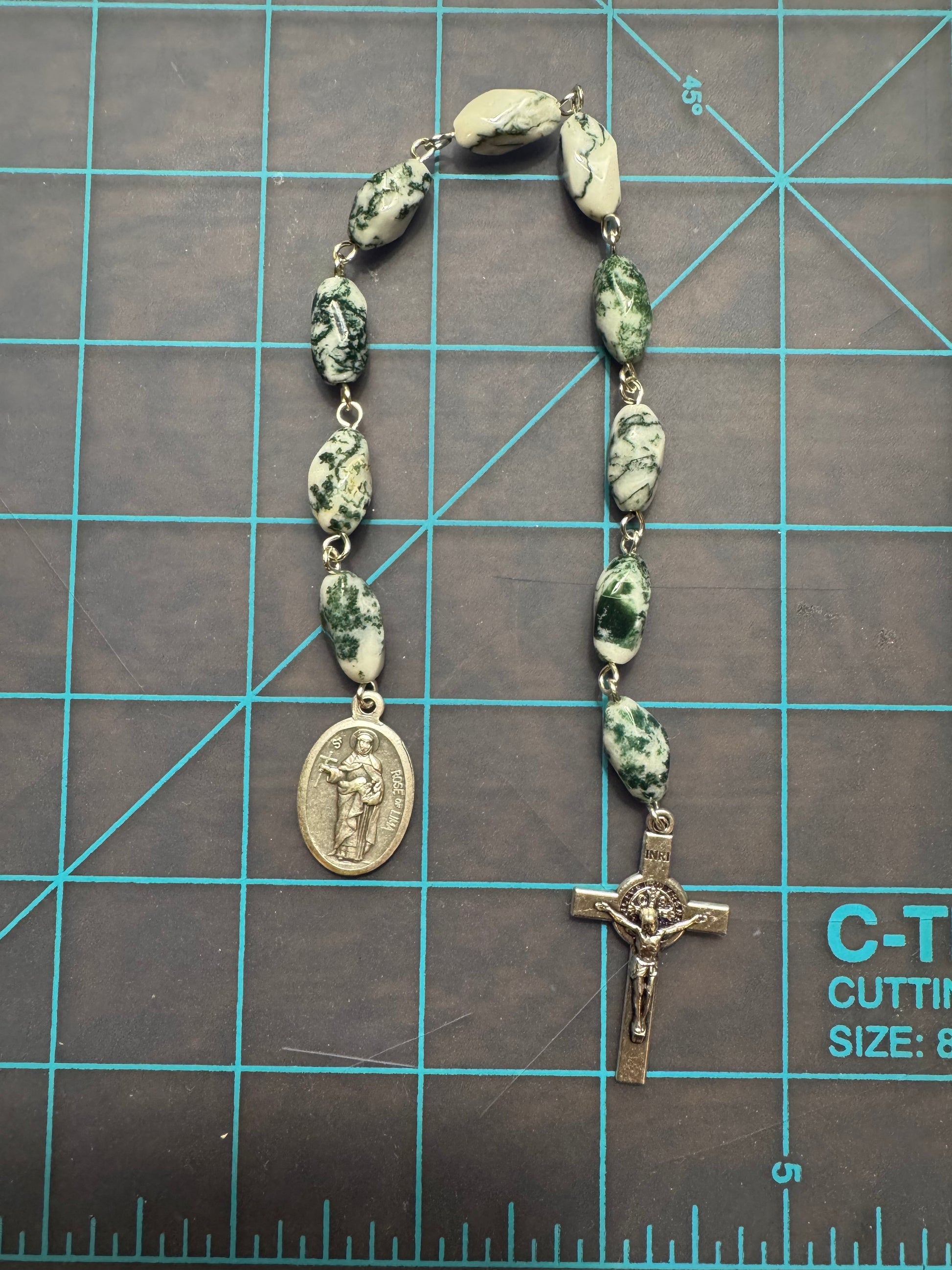 Top down view of St. Rose of Lima Pocket Rosary with green and white swirl stone beads