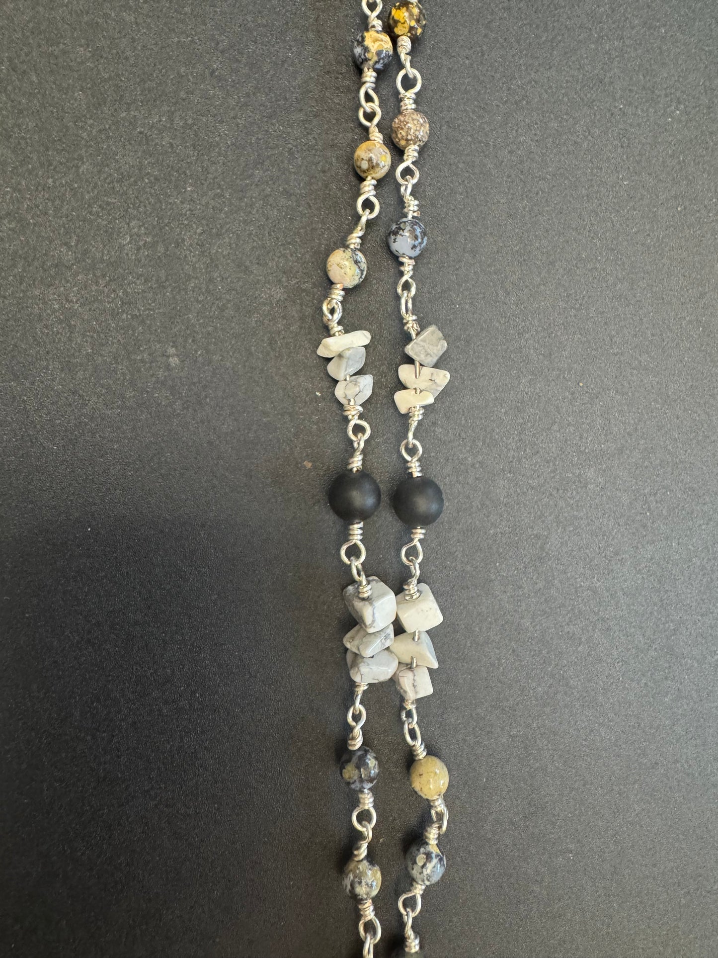 Closeup of full size rosary with gray and black stone beads