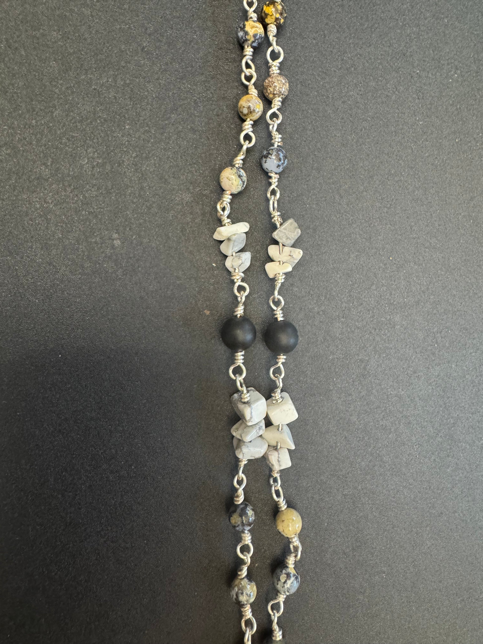 Closeup of full size rosary with gray and black stone beads