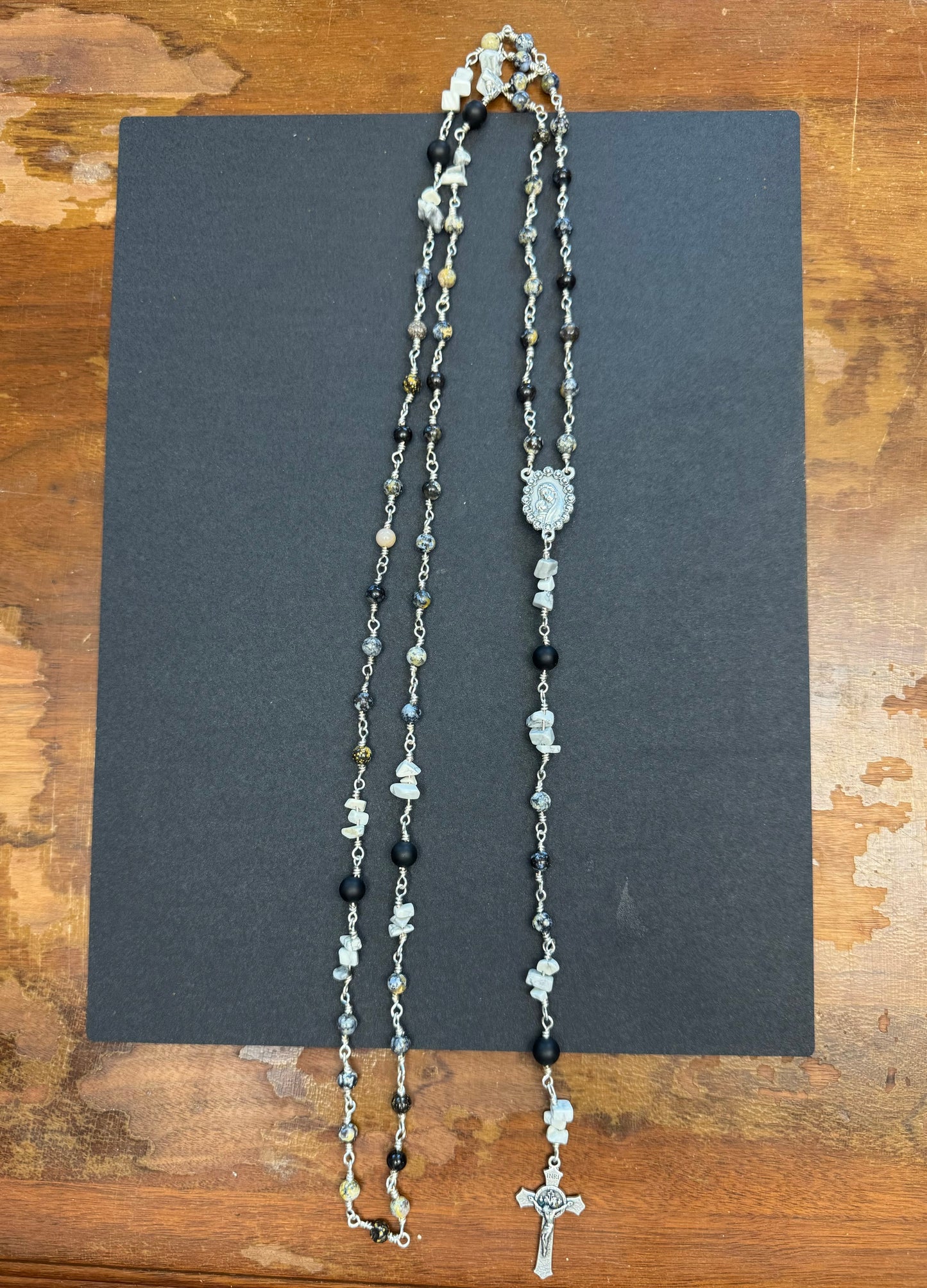 Zoomed out view of full size rosary with gray and black stone beads