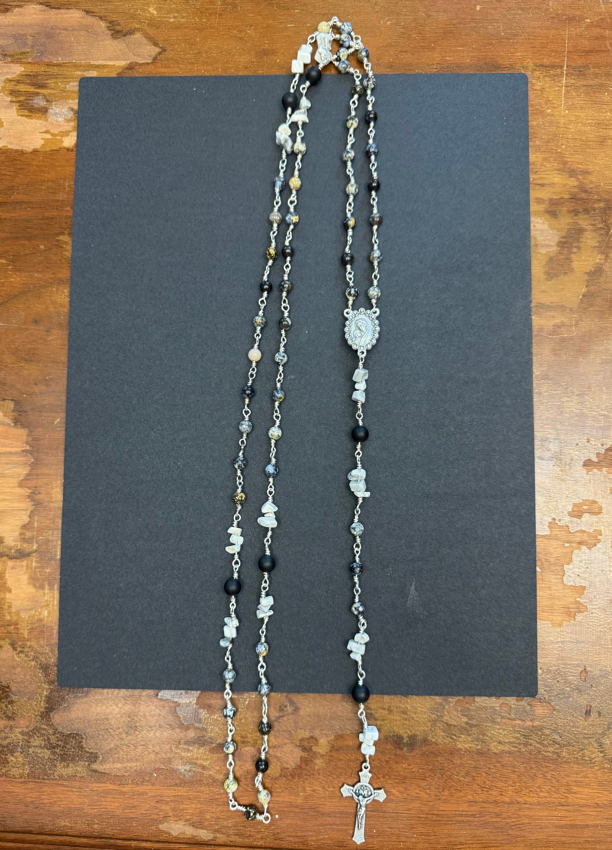 Zoomed out view of full size rosary with gray and black stone beads