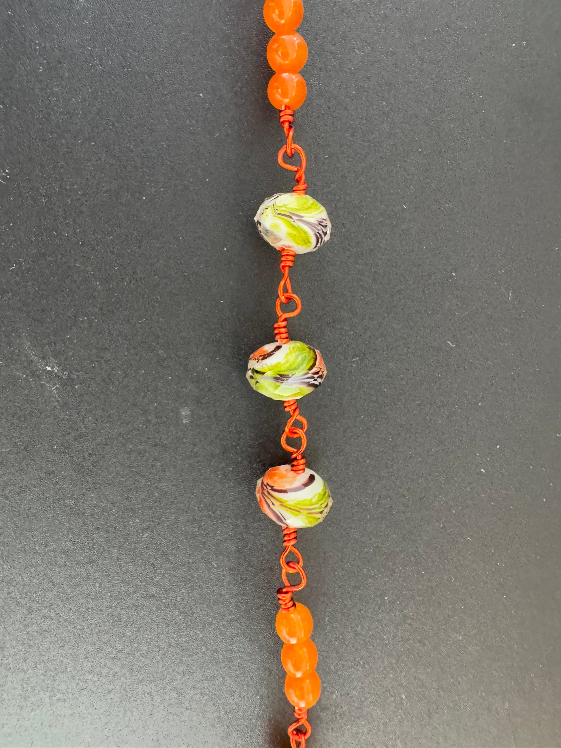 close up view of holy family orange glass bead rosary