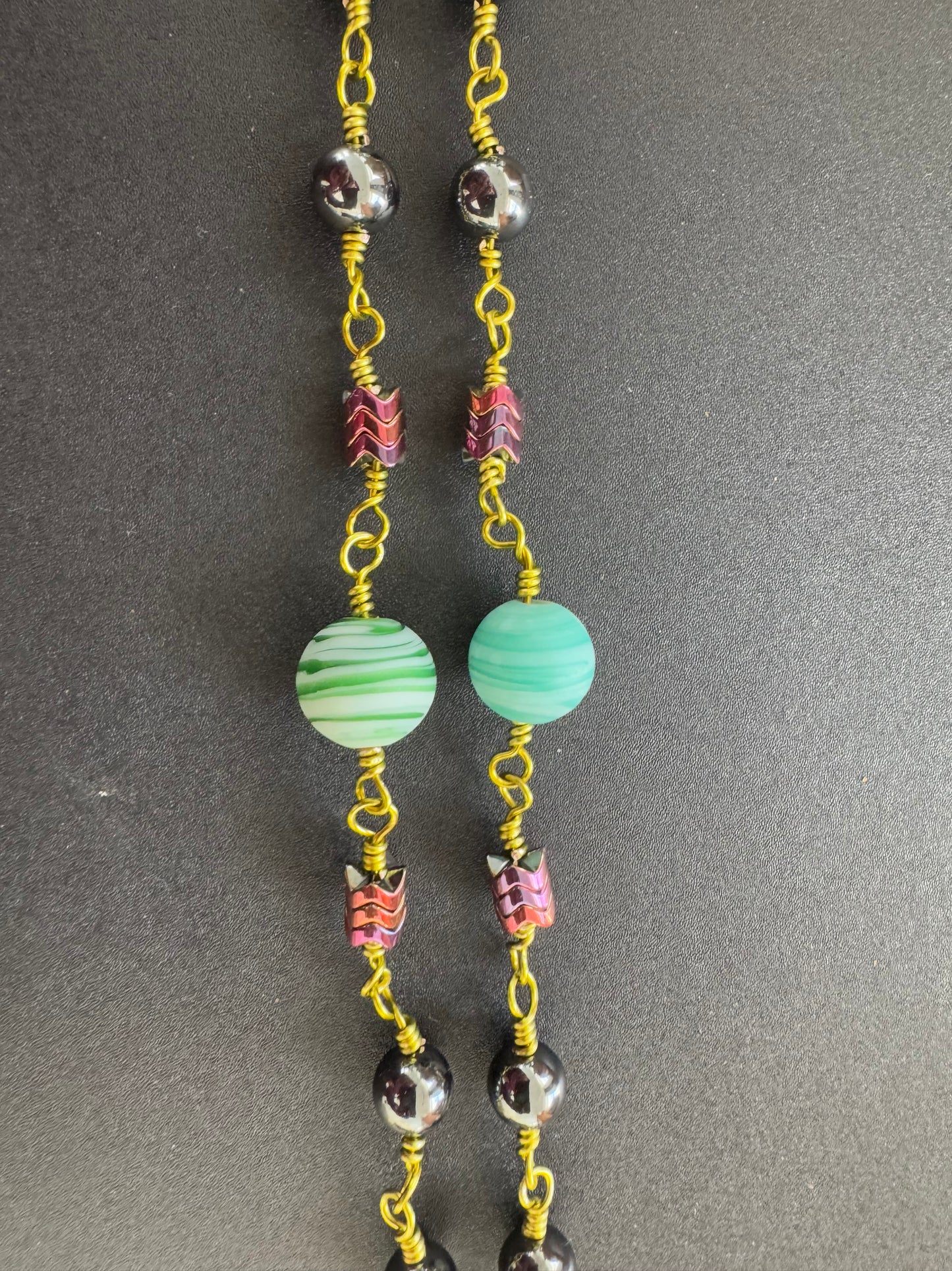 closeup of hematite rosary with green wire