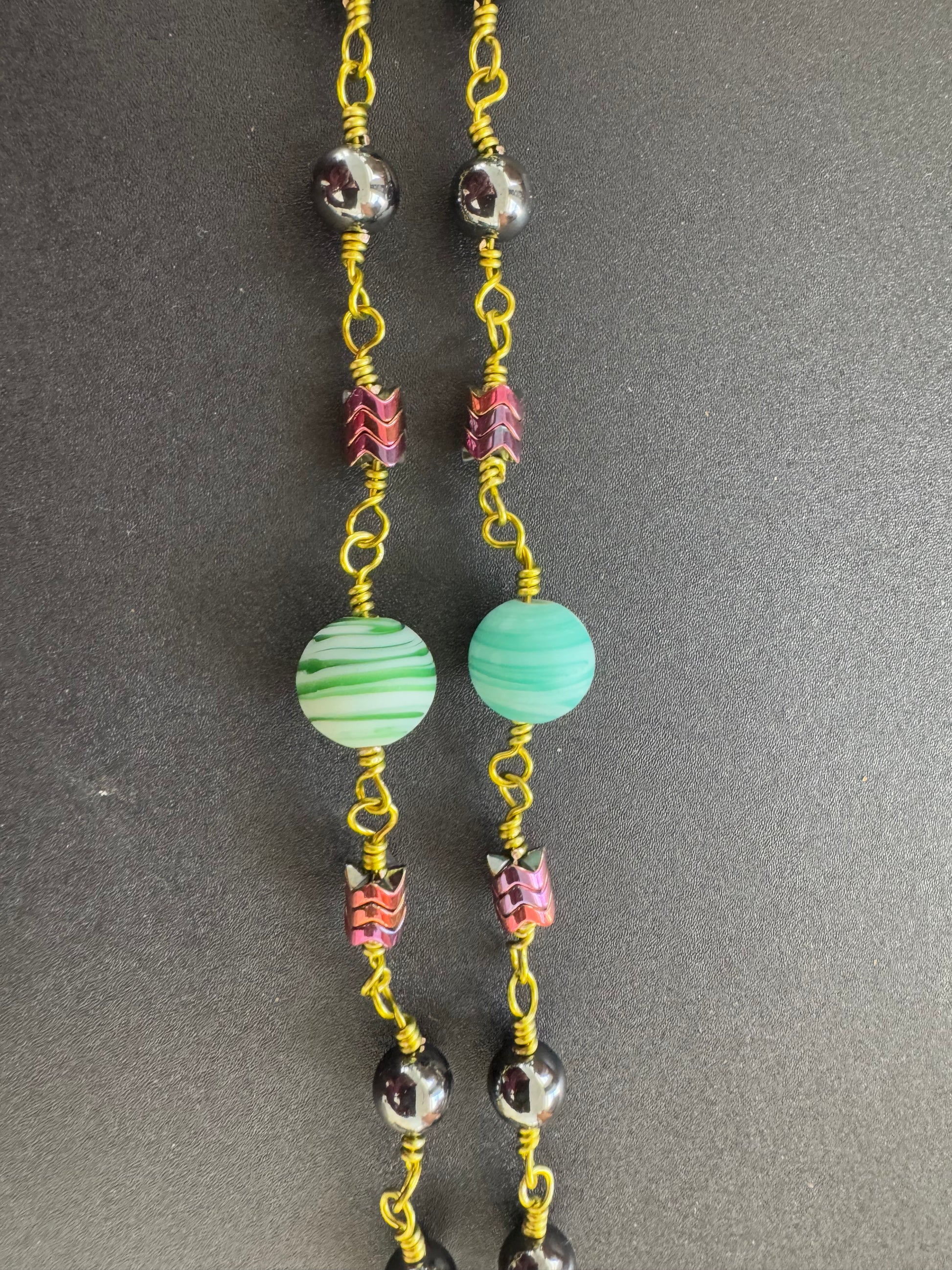 closeup of hematite rosary with green wire