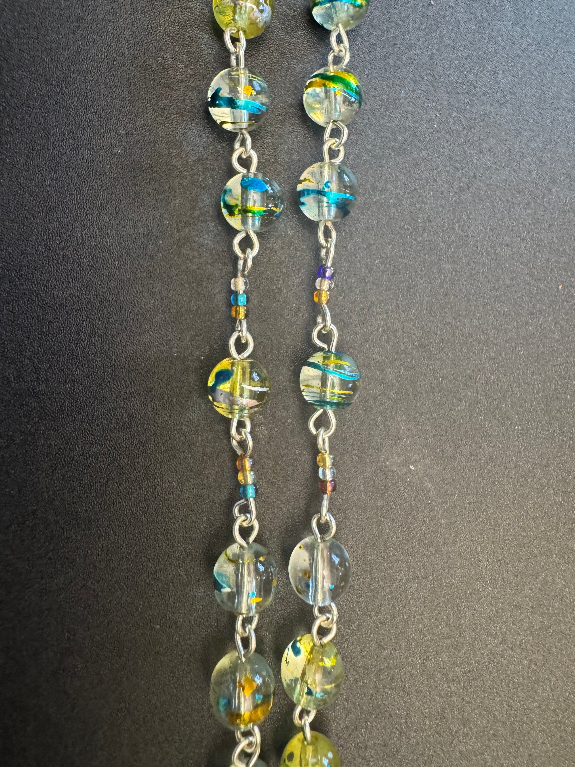 Closeup of Blue and green swirl glass bead rosary with crown of thorns centerpiece