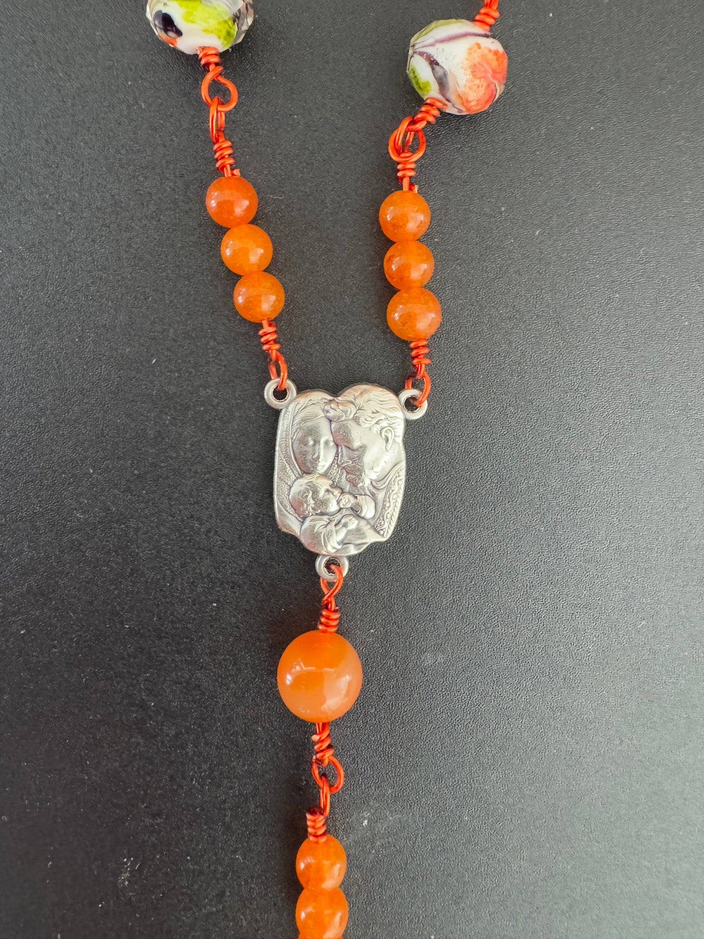holy family medal on h orange glass bead rosary