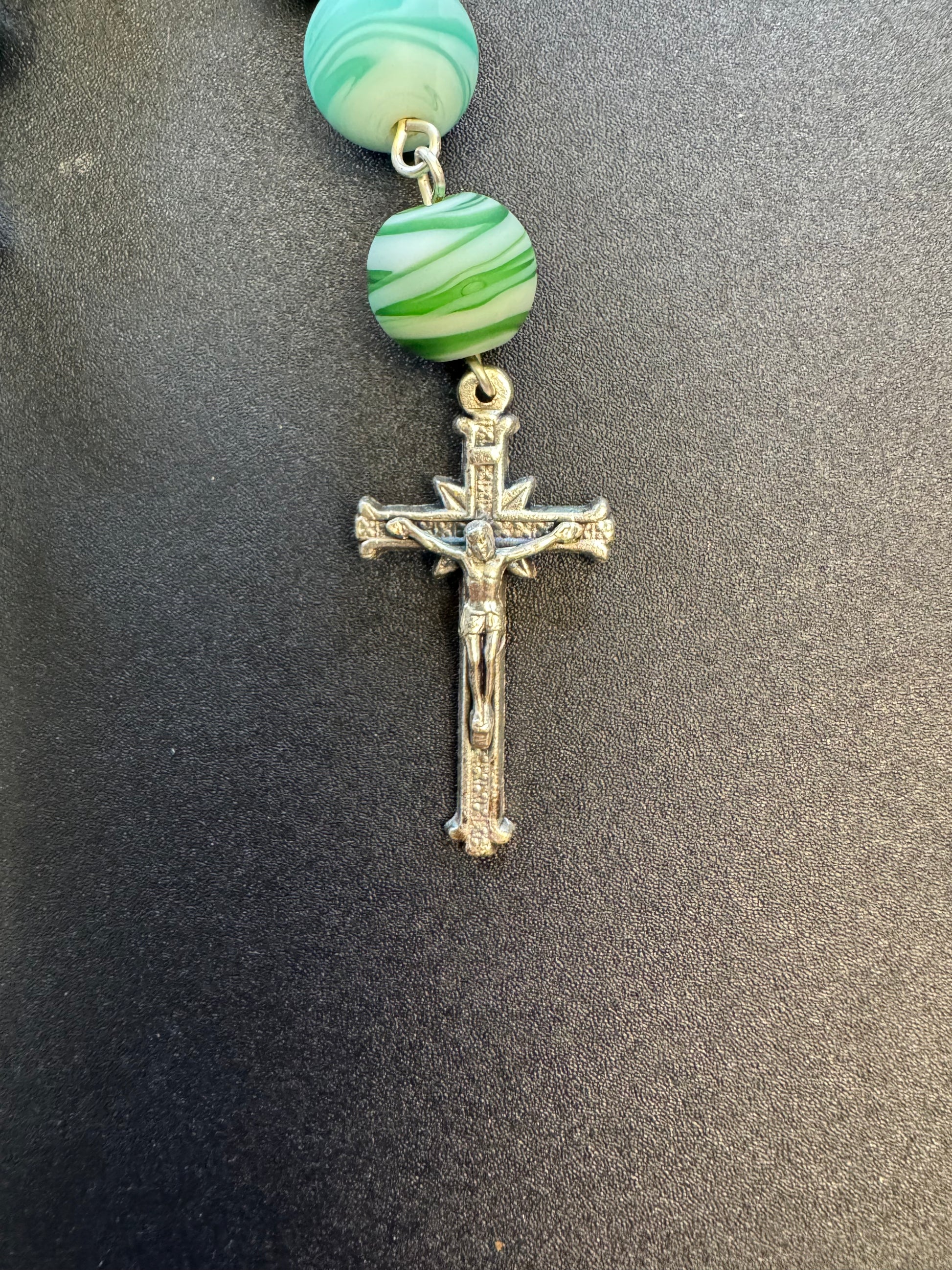 Crucifix on St. Joseph the worker pocket rosary. With blue and white swirl beads