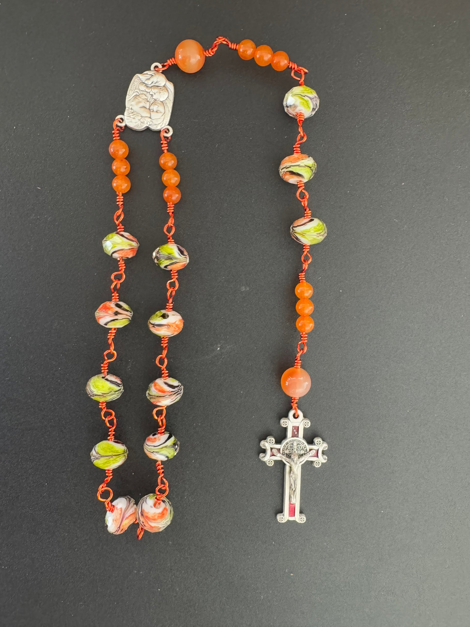 top down view of holy family orange glass bead rosary