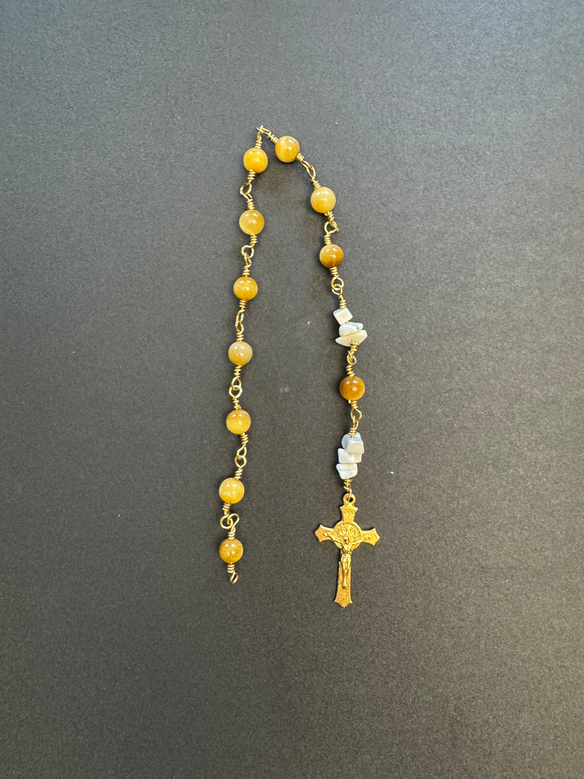 Top down view of Tiger eye pocket rosary with gold plated wire and crucifix