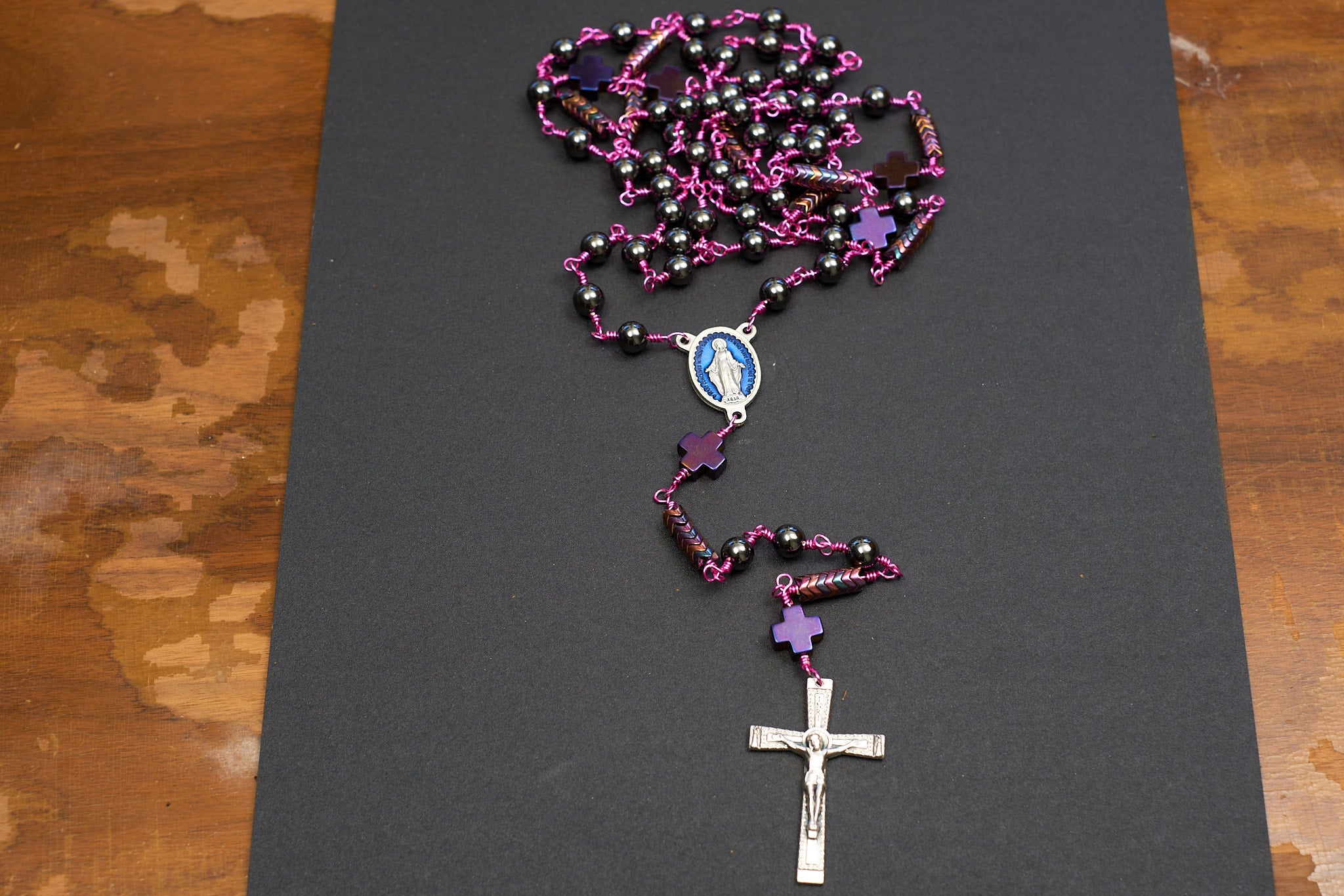 full size rosary with hematite beads and fuchsia colored wire and miraculous medal centerpiece